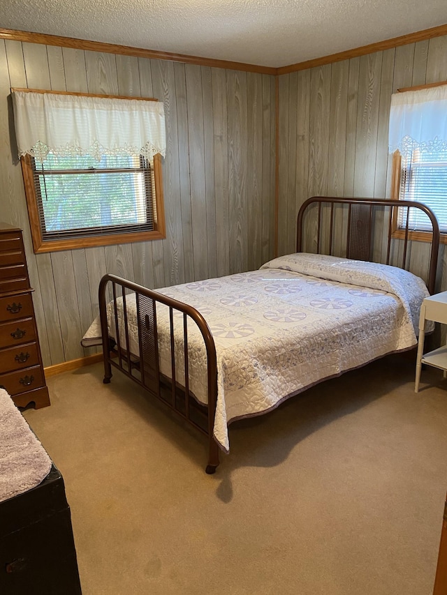 bedroom with wooden walls, carpet, and multiple windows