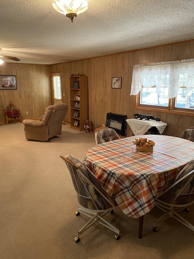 dining area featuring wooden walls, plenty of natural light, a textured ceiling, and carpet floors