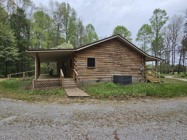 view of side of home featuring log siding and central AC unit