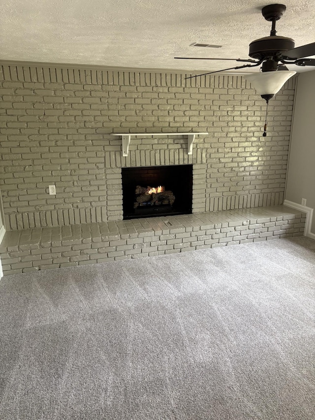 1669 Fellowship Rd, Mount Juliet, TN 37122 - unfurnished living room with a ceiling fan, carpet floors, a fireplace, a textured ceiling, and brick wall