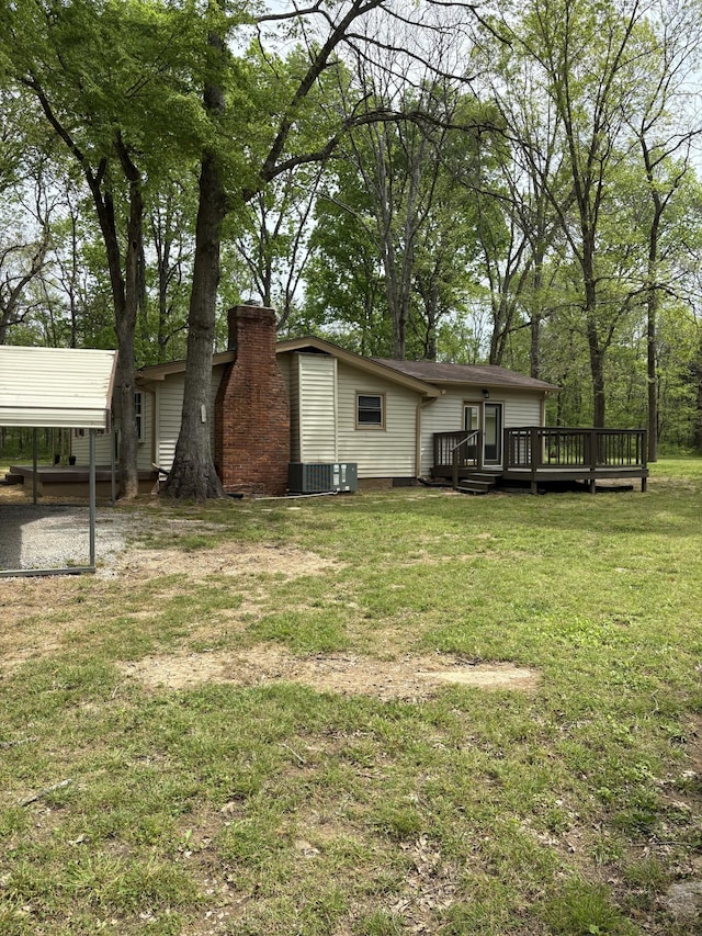 1669 Fellowship Rd, Mount Juliet, TN 37122 - back of property featuring a carport, central AC, a chimney, a wooden deck, and a lawn