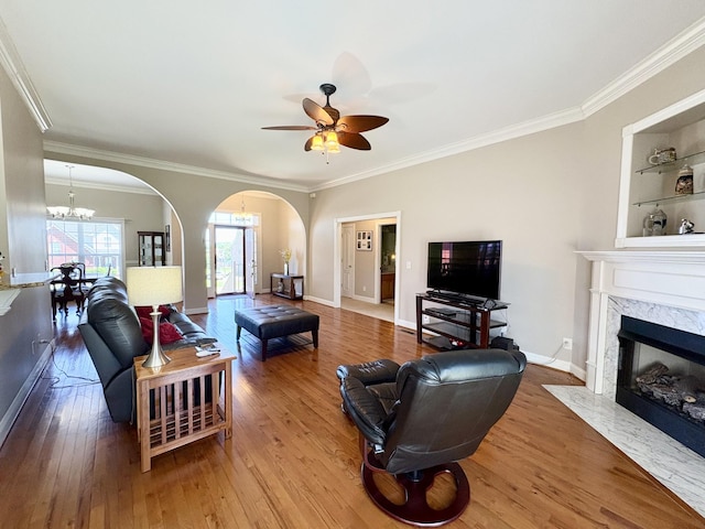 2001 Butler Cv, Lebanon, TN 37087 - living room featuring arched walkways, a chandelier, ornamental molding, wood finished floors, and ceiling fan