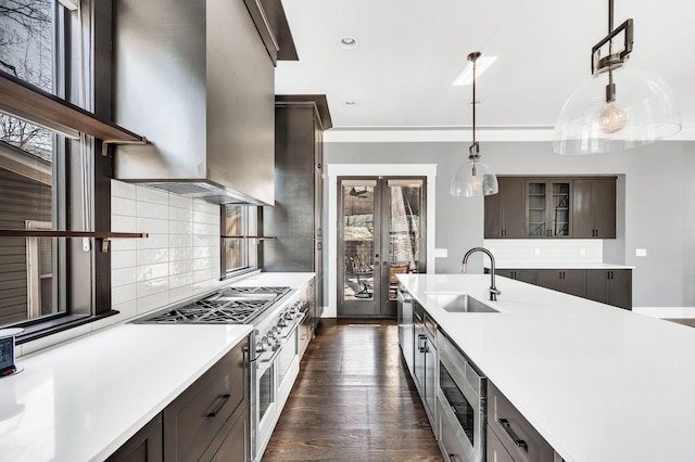 3503 Elkins Ave, Nashville, TN 37209 - kitchen with light countertops, wall chimney range hood, a sink, dark brown cabinetry, and appliances with stainless steel finishes