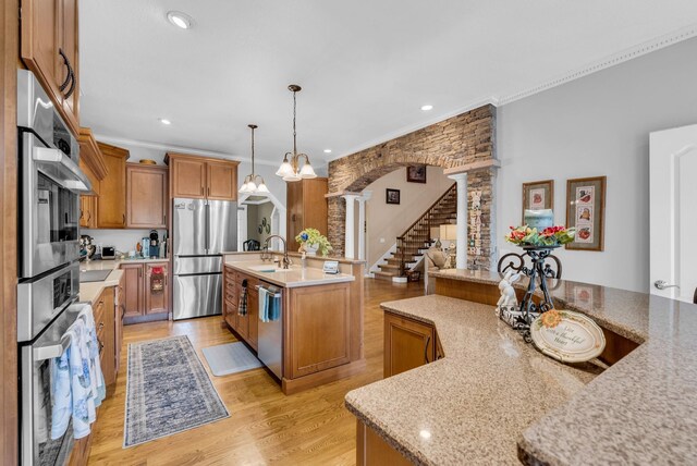 321 Clinchfield Dr, Monterey, TN 38574 - kitchen featuring a sink, brown cabinetry, an island with sink, stainless steel appliances, and ornate columns