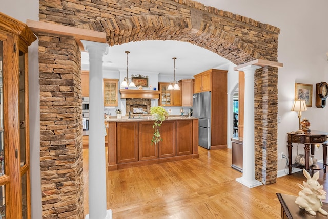 321 Clinchfield Dr, Monterey, TN 38574 - kitchen with hanging light fixtures, light wood-style floors, decorative columns, glass insert cabinets, and appliances with stainless steel finishes