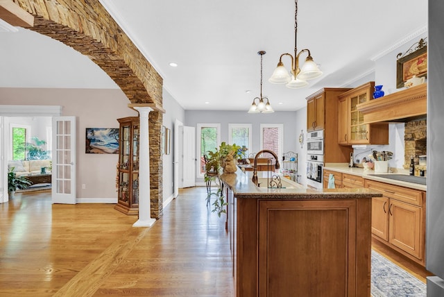 321 Clinchfield Dr, Monterey, TN 38574 - kitchen with a sink, light wood-type flooring, decorative columns, a chandelier, and an island with sink
