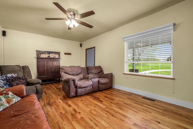 living area featuring ceiling fan, baseboards, visible vents, and light wood-style flooring