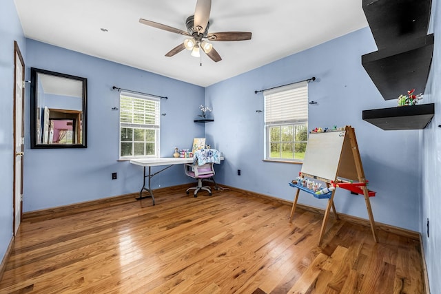 office space with baseboards, a ceiling fan, and wood finished floors