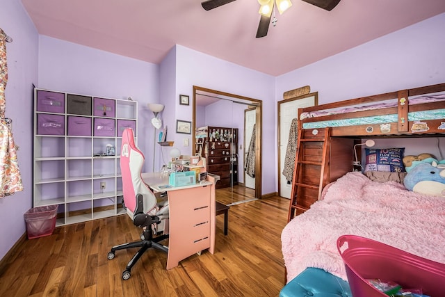 bedroom with a ceiling fan, wood finished floors, and a closet