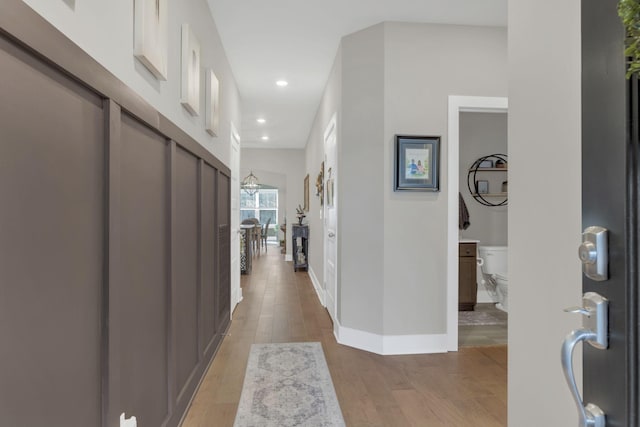 hall with baseboards, recessed lighting, and light wood-style floors