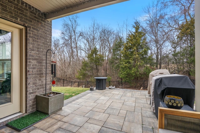 view of patio featuring a grill and fence
