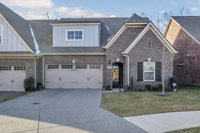 view of front of property featuring board and batten siding, a garage, a front lawn, and concrete driveway