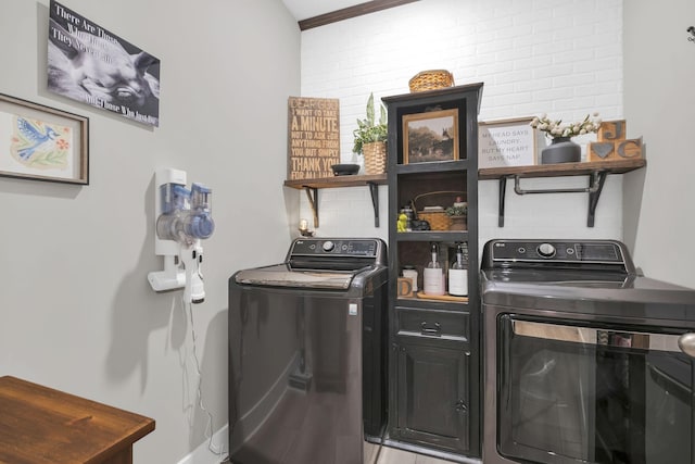 clothes washing area with separate washer and dryer and cabinet space
