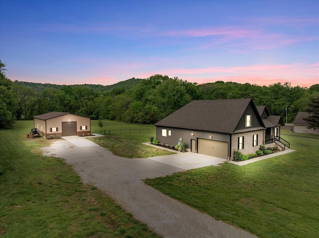 view of front of property featuring an outbuilding, a detached garage, concrete driveway, fence, and a yard