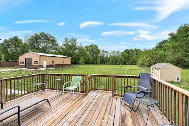 wooden terrace with a fenced backyard, an outbuilding, and a lawn