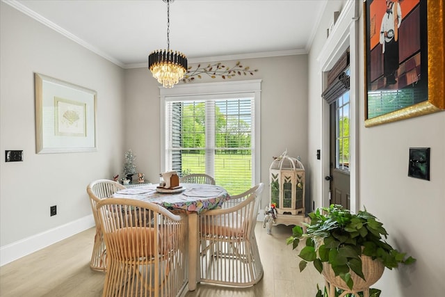 dining space featuring an inviting chandelier, ornamental molding, wood finished floors, and a wealth of natural light