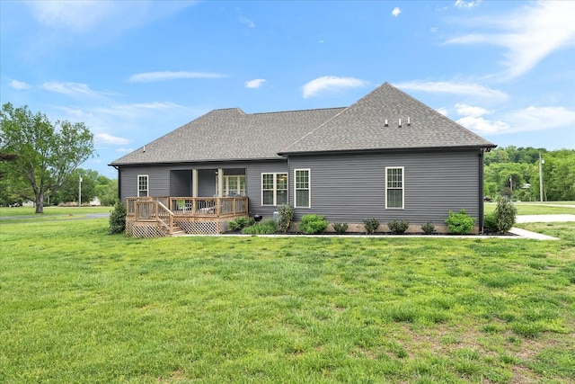 back of house with a wooden deck, a yard, and a shingled roof