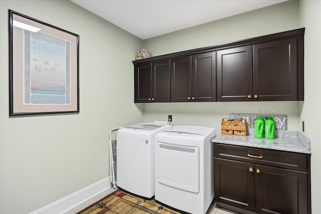 clothes washing area with baseboards, cabinet space, and independent washer and dryer