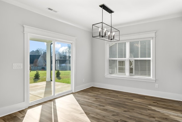 unfurnished dining area with visible vents, baseboards, wood finished floors, and a chandelier