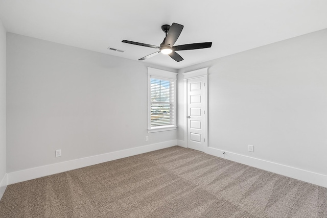 carpeted spare room with a ceiling fan, visible vents, and baseboards