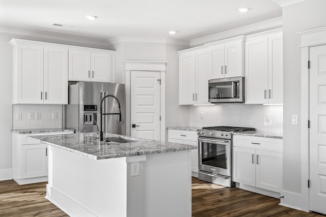 kitchen with dark wood-style floors, a sink, stainless steel appliances, visible vents, and backsplash