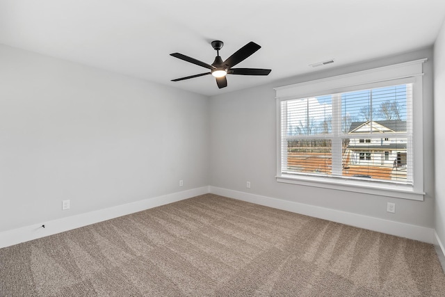 spare room with baseboards, visible vents, a ceiling fan, and carpet floors