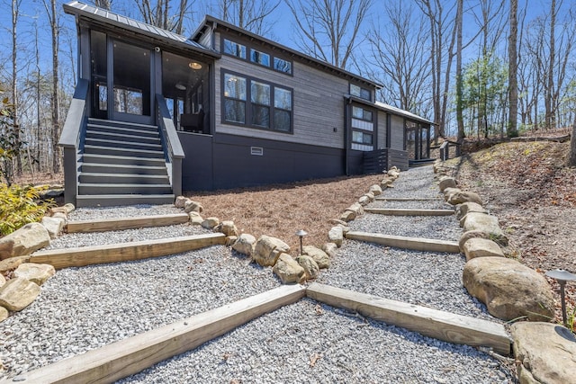 view of front of house with stairway, crawl space, and a sunroom