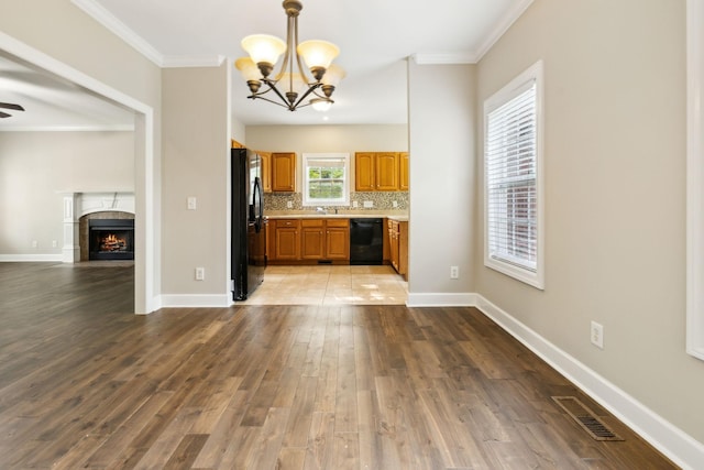 436 Conquest Rd N, Murfreesboro, TN 37128 - kitchen with black appliances, open floor plan, brown cabinetry, a chandelier, and light countertops