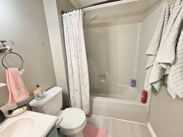 bathroom with toilet, baseboards, wood finished floors, shower / bathtub combination with curtain, and vanity