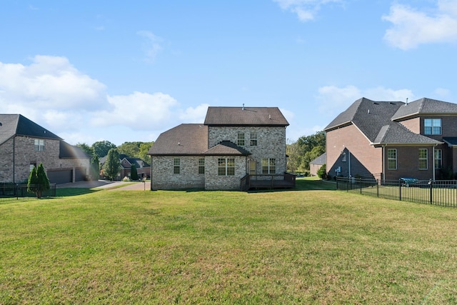 rear view of property with a lawn, fence, and stone siding