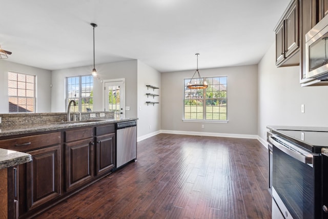 kitchen with dark brown cabinetry, stainless steel appliances, a sink, and plenty of natural light