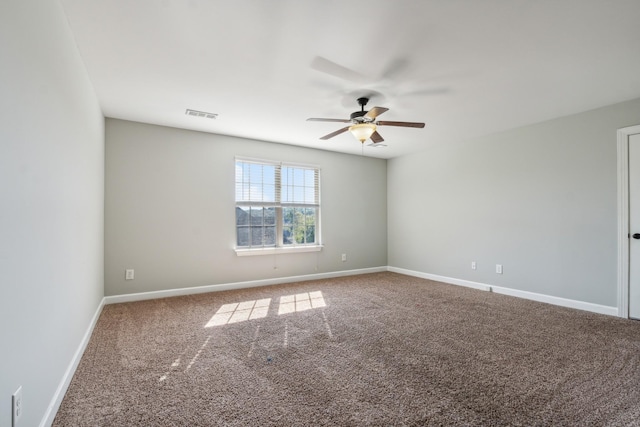 carpeted spare room featuring ceiling fan, baseboards, and visible vents