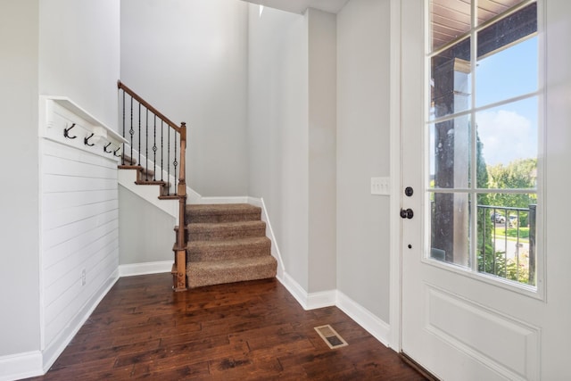 entrance foyer featuring baseboards, visible vents, stairs, and dark wood-style flooring