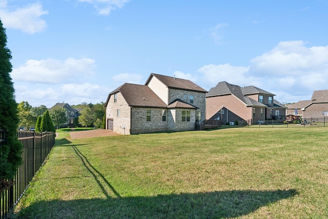 exterior space with a fenced backyard, an attached garage, brick siding, and a yard
