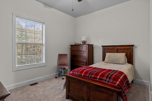 bedroom featuring visible vents, baseboards, multiple windows, and light colored carpet