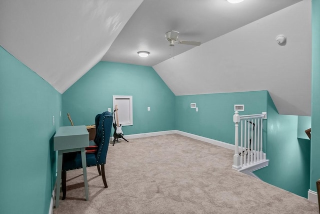 carpeted office with vaulted ceiling, a ceiling fan, visible vents, and baseboards