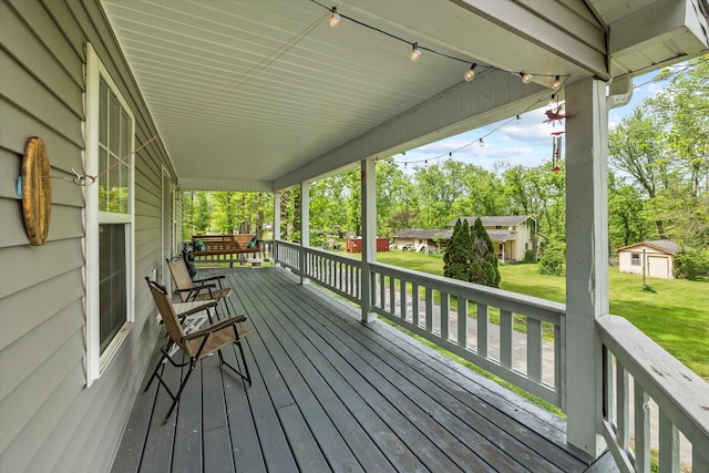 wooden deck featuring a porch and a yard