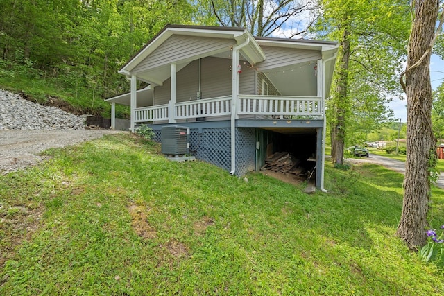 view of front of house featuring a deck, cooling unit, and a front yard