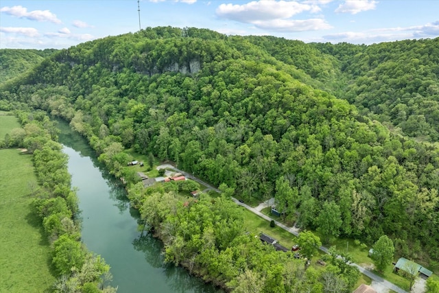 birds eye view of property featuring a forest view and a water view