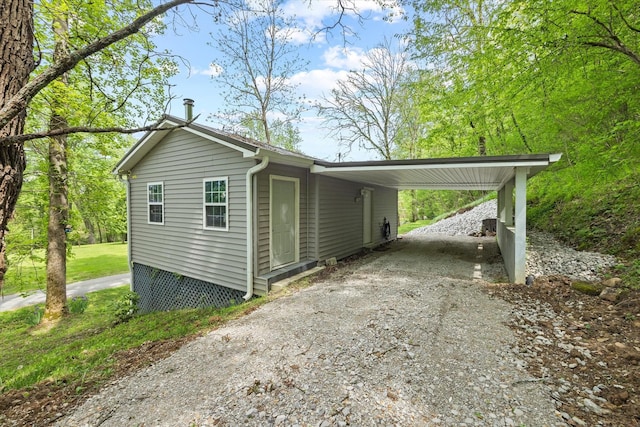 view of side of property featuring driveway and a carport