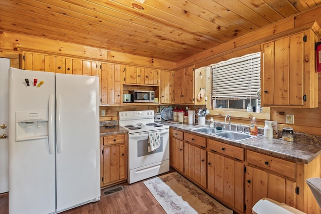 kitchen featuring dark countertops, a sink, white appliances, wood ceiling, and visible vents