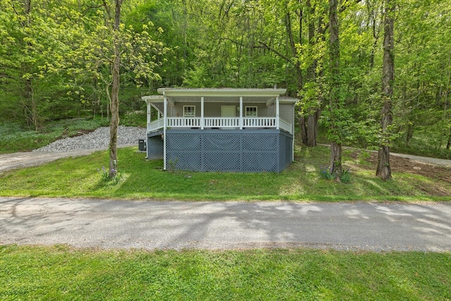 view of front of property with a forest view and a front yard