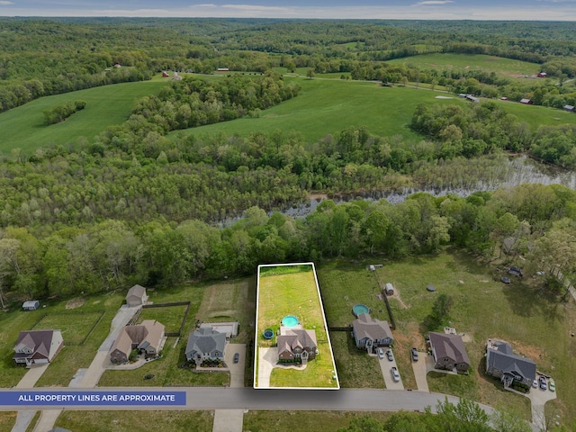 drone / aerial view featuring a wooded view