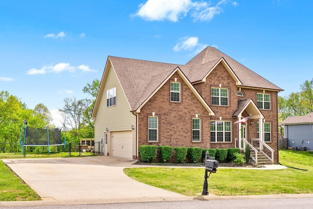 view of front of home featuring a trampoline, a front lawn, driveway, an attached garage, and brick siding