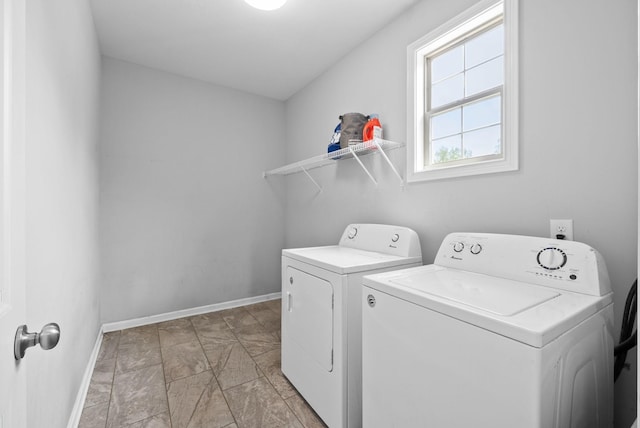laundry room featuring baseboards, washing machine and clothes dryer, stone finish floor, and laundry area