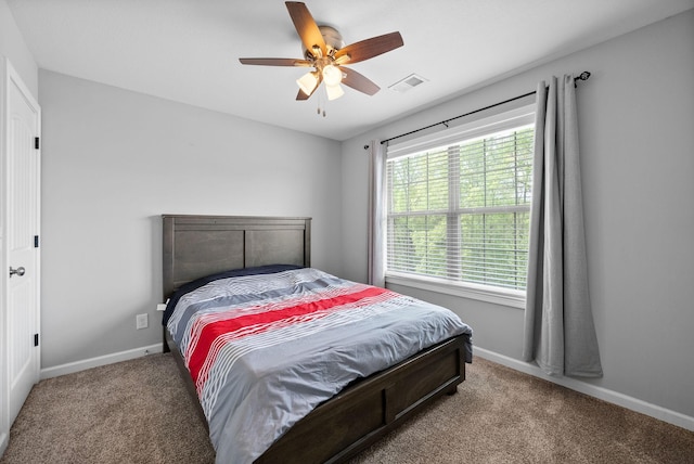 carpeted bedroom with visible vents, baseboards, and ceiling fan