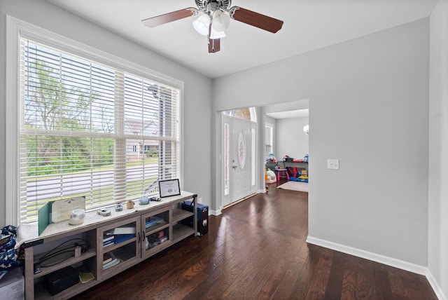 interior space with baseboards, a ceiling fan, and wood finished floors