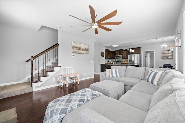 living area with a ceiling fan, baseboards, stairs, and dark wood-style flooring