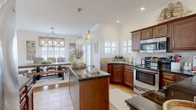 1100 Cypress Rd, Buchanan, TN 38222 - kitchen with crown molding, a sink, a kitchen island with sink, stainless steel appliances, and decorative light fixtures