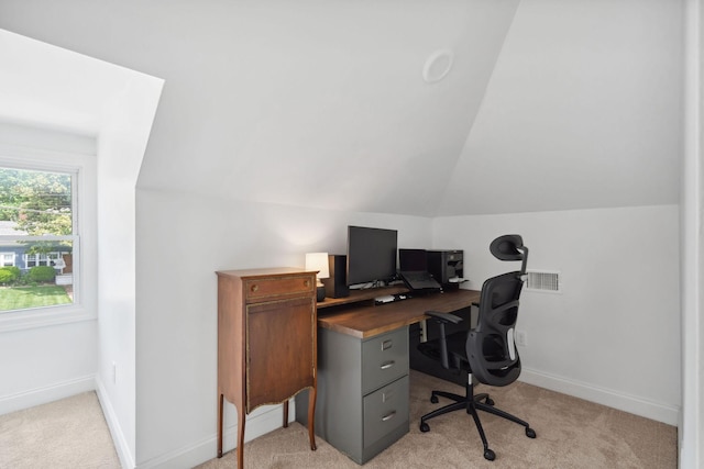 office area with visible vents, vaulted ceiling, baseboards, and light colored carpet